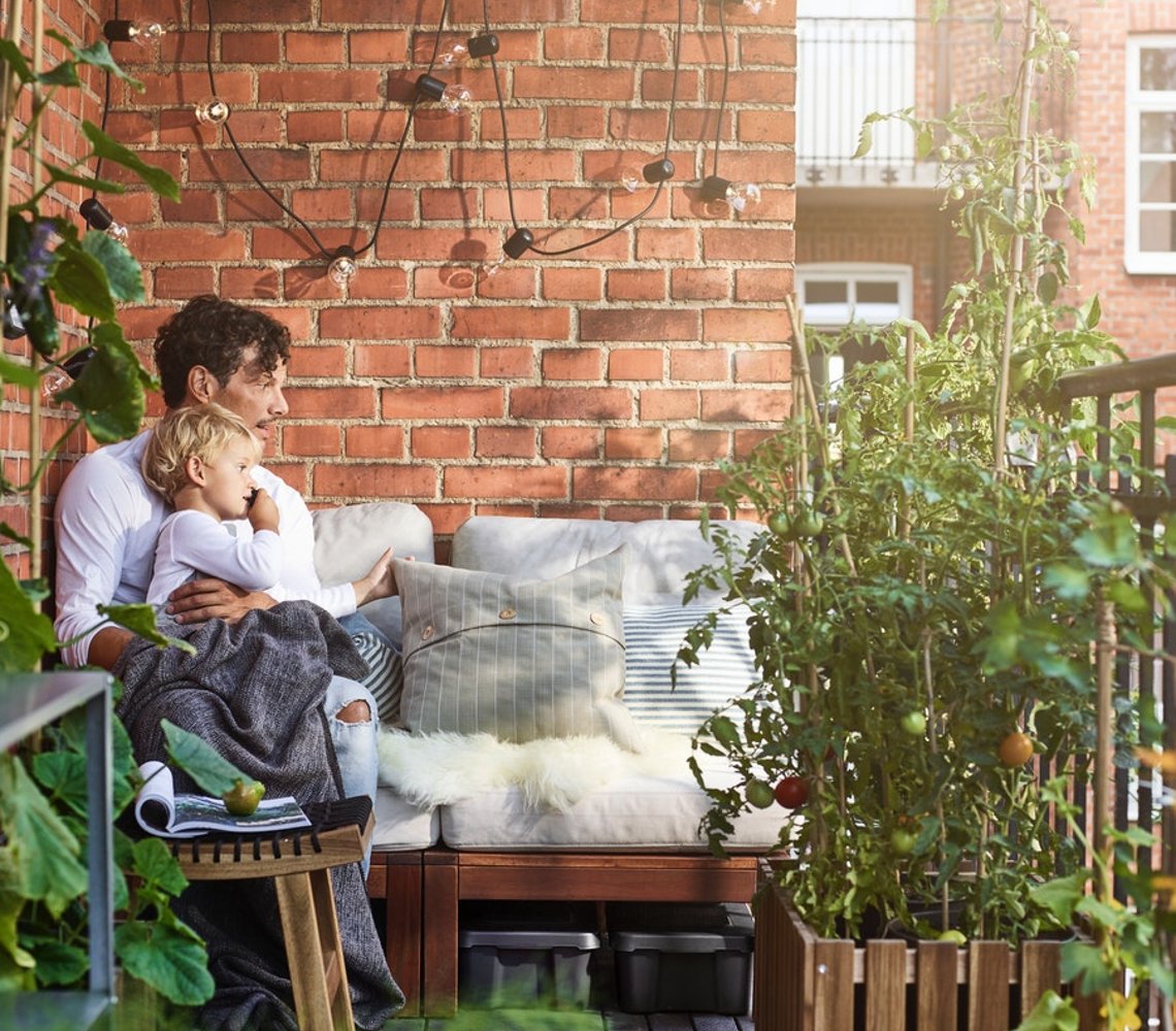 Dad and child enjoying a sunny day on a balcony.