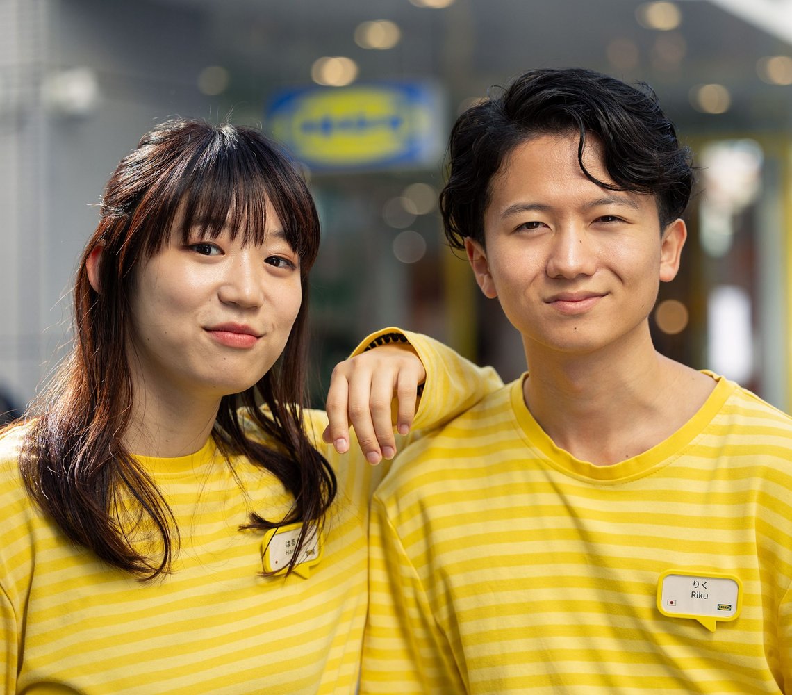 Two IKEA colleagues wearing yellow shirts standing in a store.