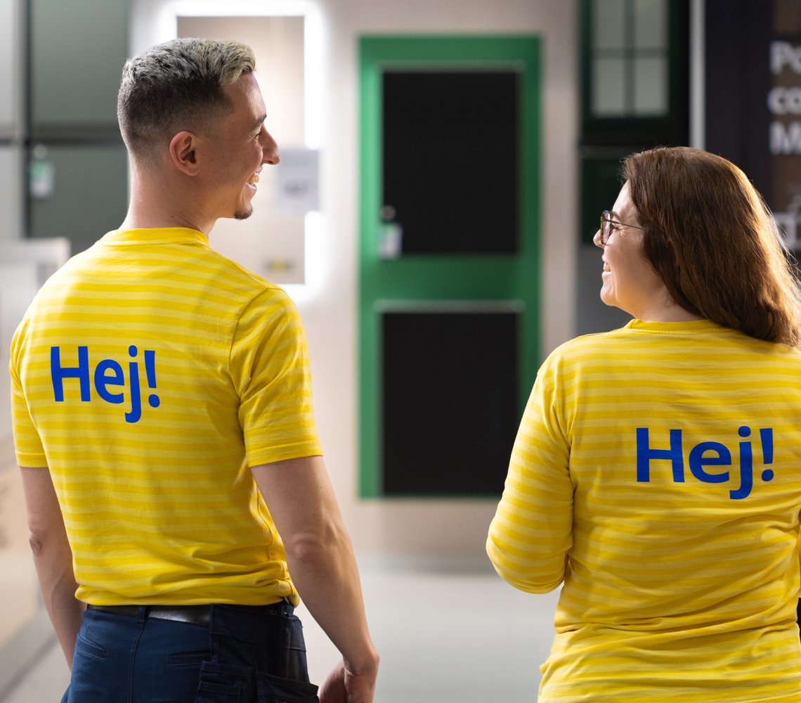 Two IKEA co-workers smiling at each other.