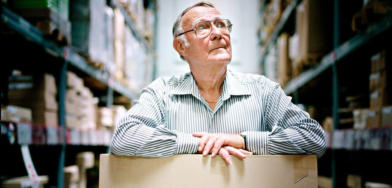 Ingvar Kamprad standing in the IKEA store ware-house with a cardboard box.