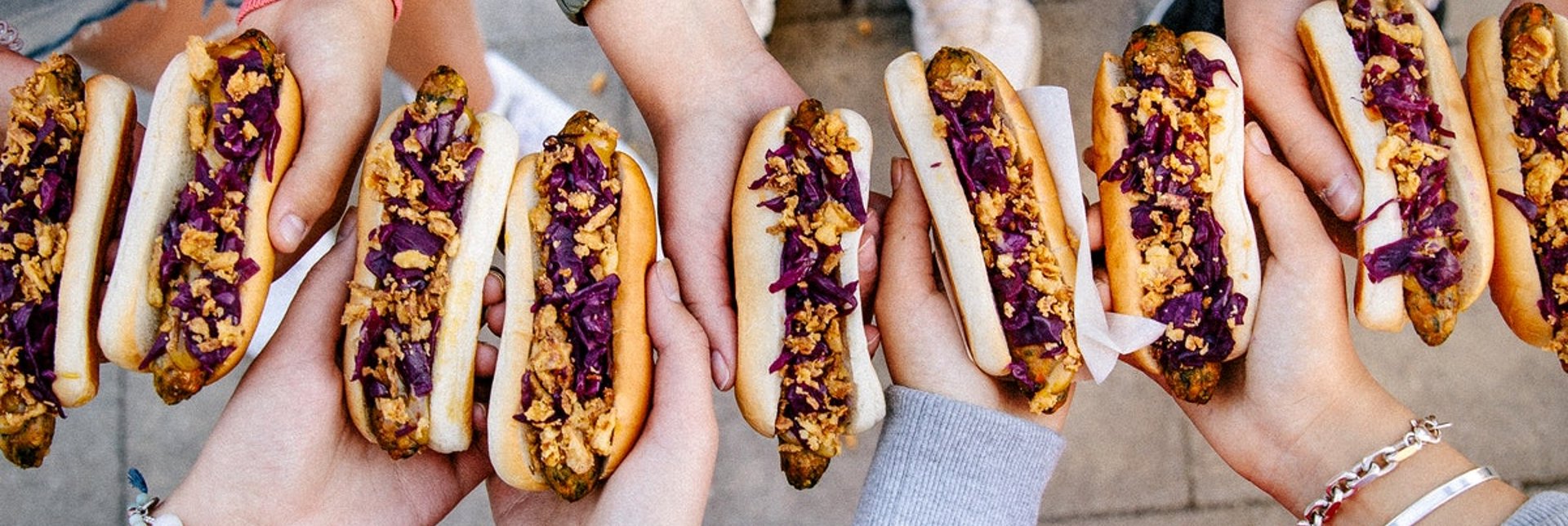 A group of friends holding veggie hotdogs.