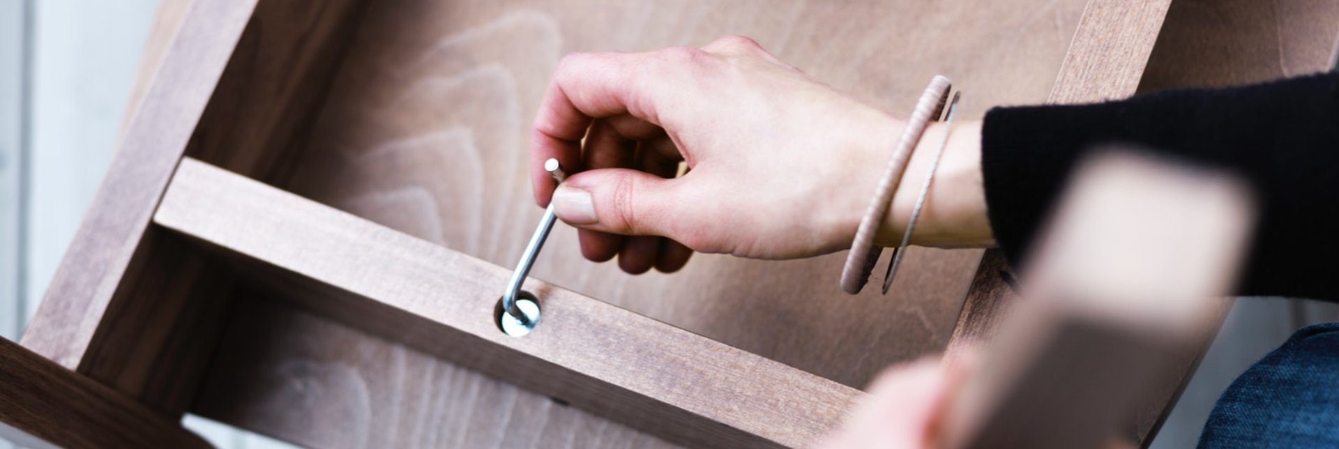 Woman assembling a chair with an allen key.