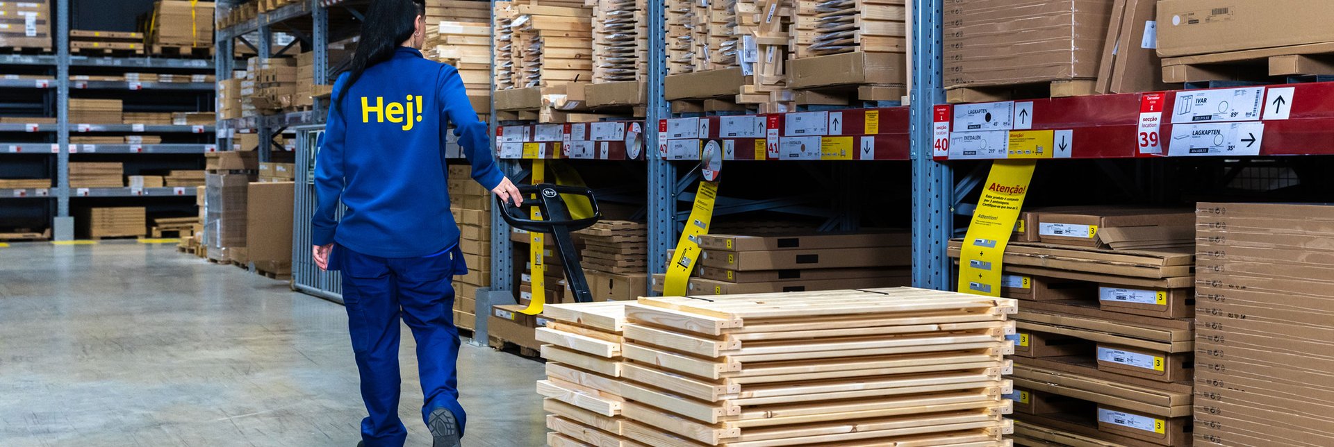 An IKEA employee with a hand truck restocking in the stores Self-service area