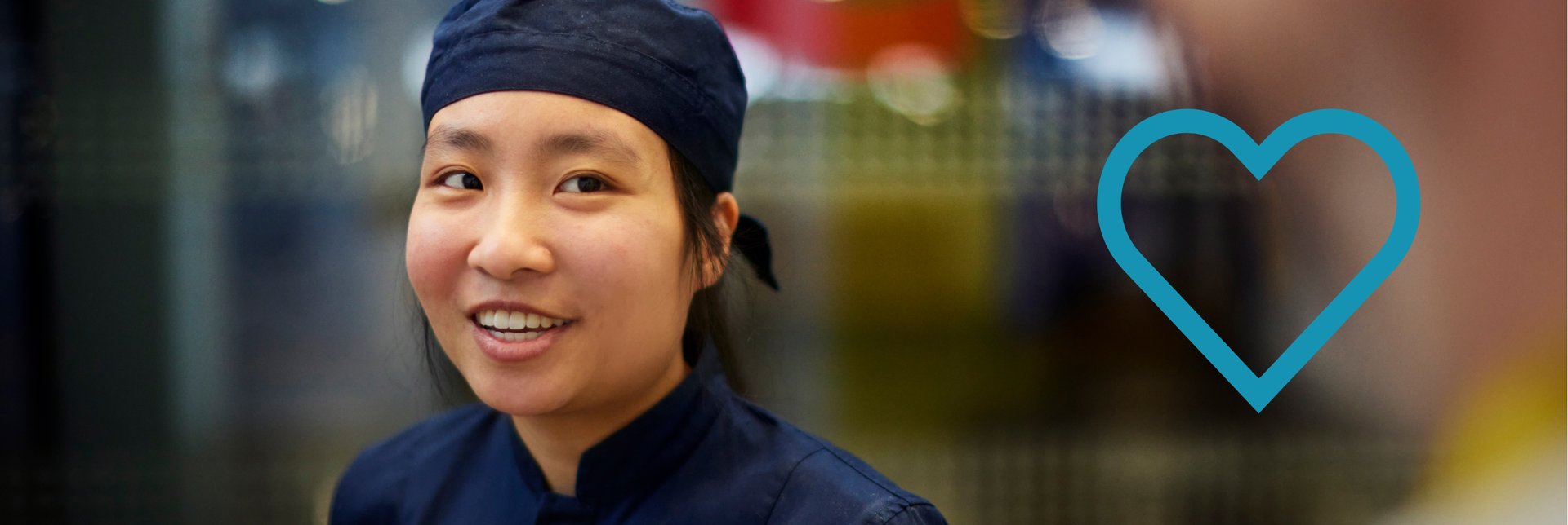 An IKEA Food co-worker wearing a blue work uniform in front of a blurred background.