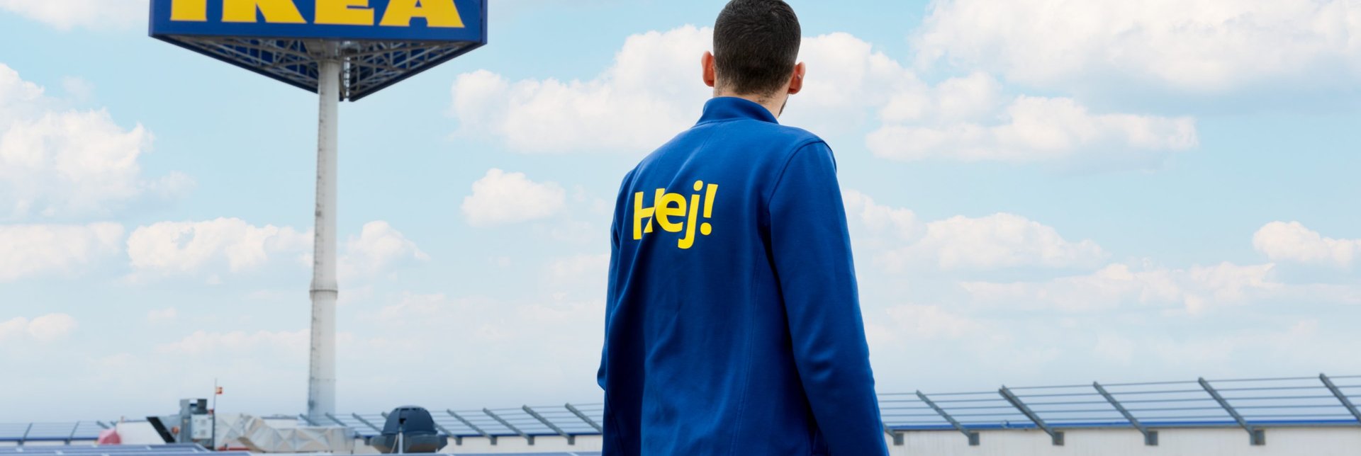 An IKEA co-worker standing on a stores roof looking over solar panels.