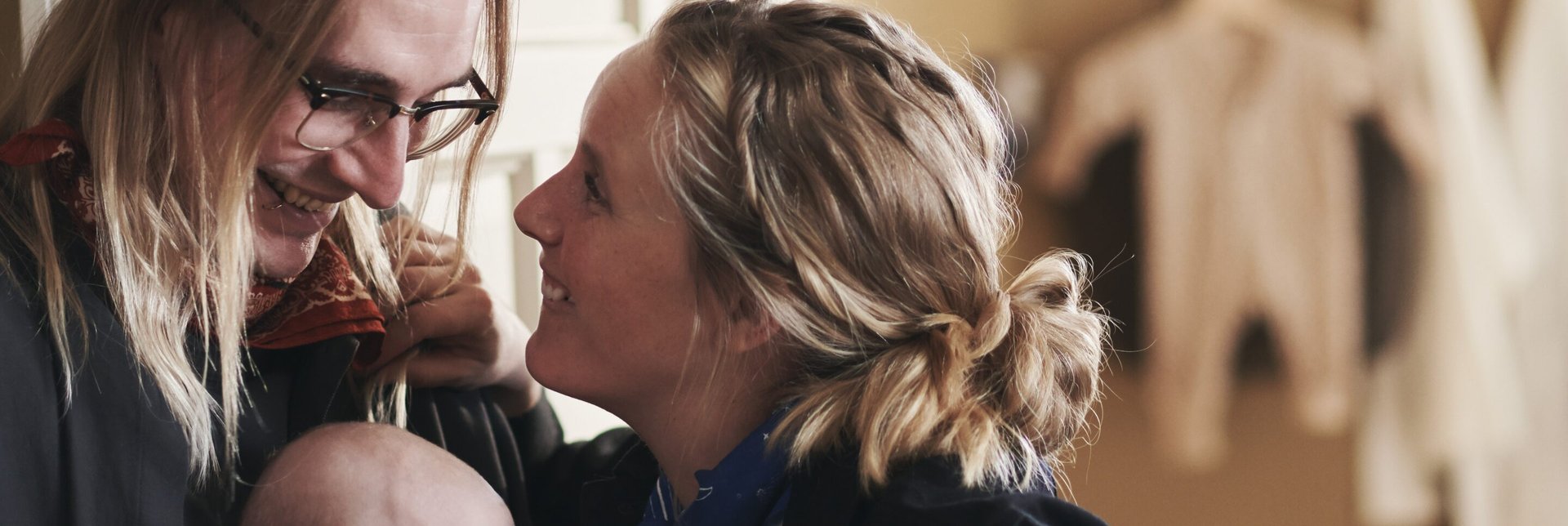 Couple look at each other while holding a baby