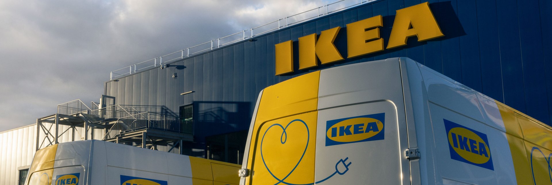 Electric vans parked in front of an IKEA store.