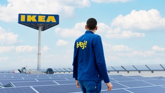 An IKEA co-worker standing on a stores roof looking over solar panels.