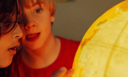 Two children looking at a globe.