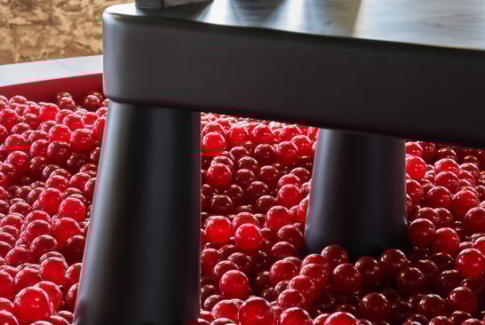 Close-up of a large black chair standing on red balls