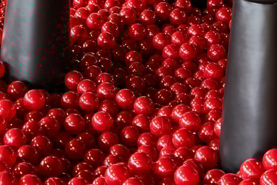 Close-up of a large black chair standing on red balls