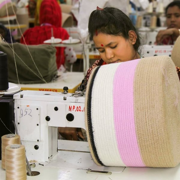 Woman sewing textiles at IKEA supplier factory.