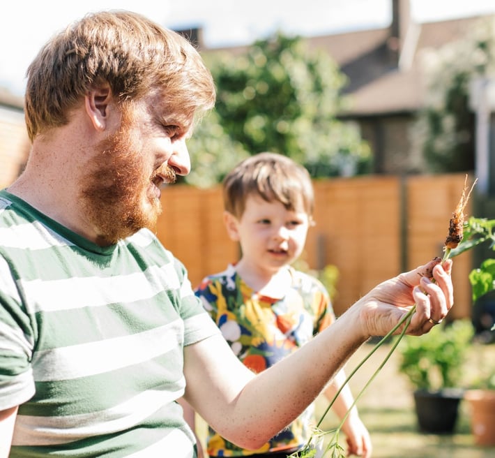 Man and child in a garden with plants