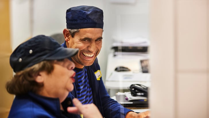 Two IKEA co-workers laughing.