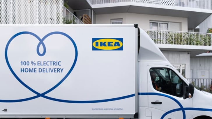 An IKEA home delivery truck parked in front of a white building