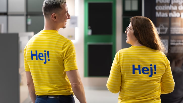 Two IKEA co-workers smiling at each other.