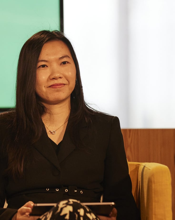 Zhilin Xiao sitting in a yellow chair participating in a panel discussion.