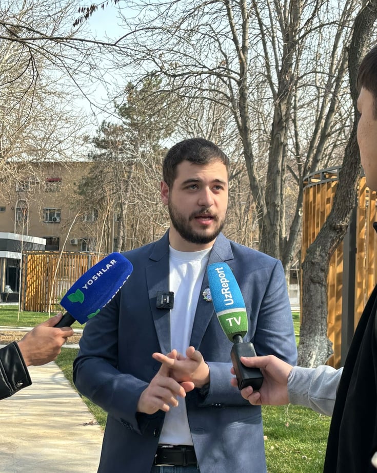 Michael Bäcklund​ standing outside being interviewed by the press.