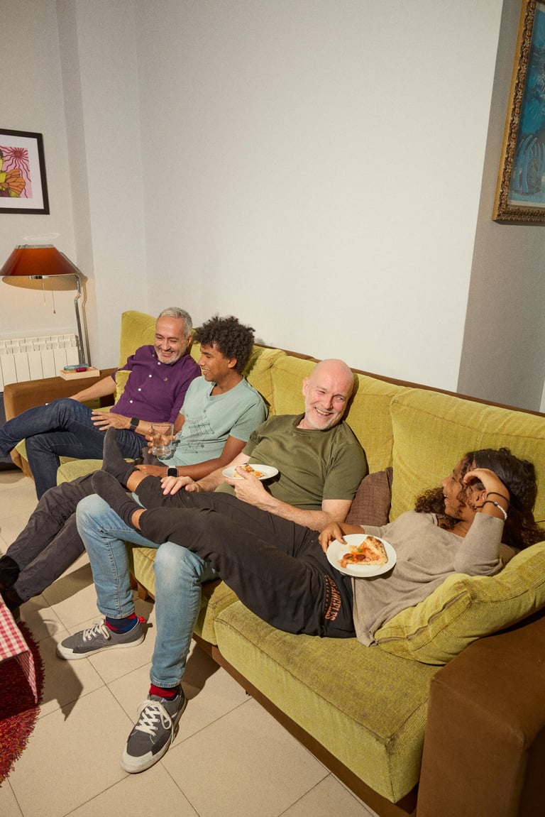 A family sitting on a couch, laughing.