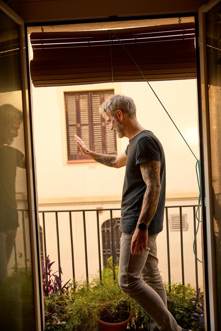 A man waving from his balcony.