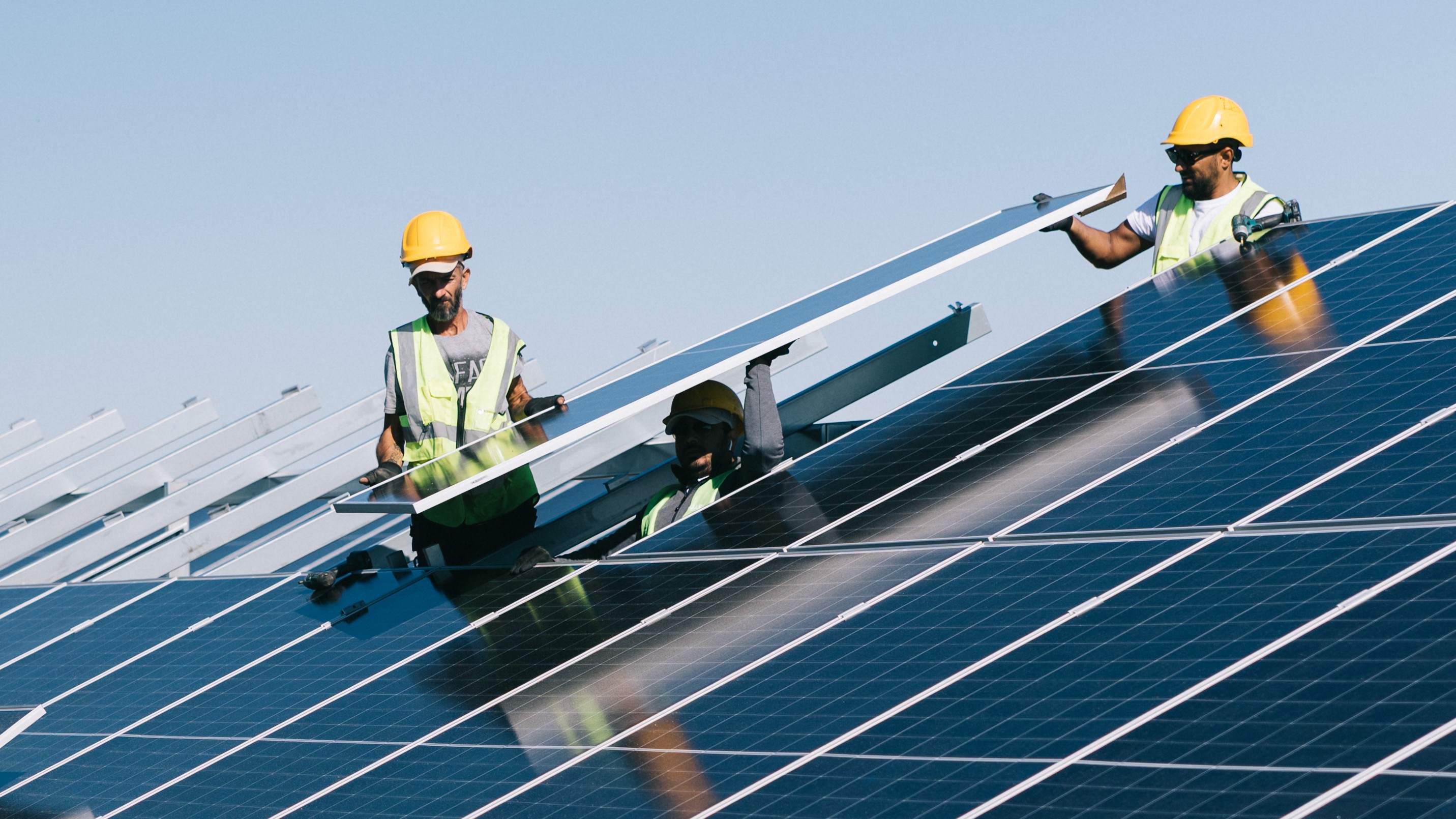 Three men installing solar panels