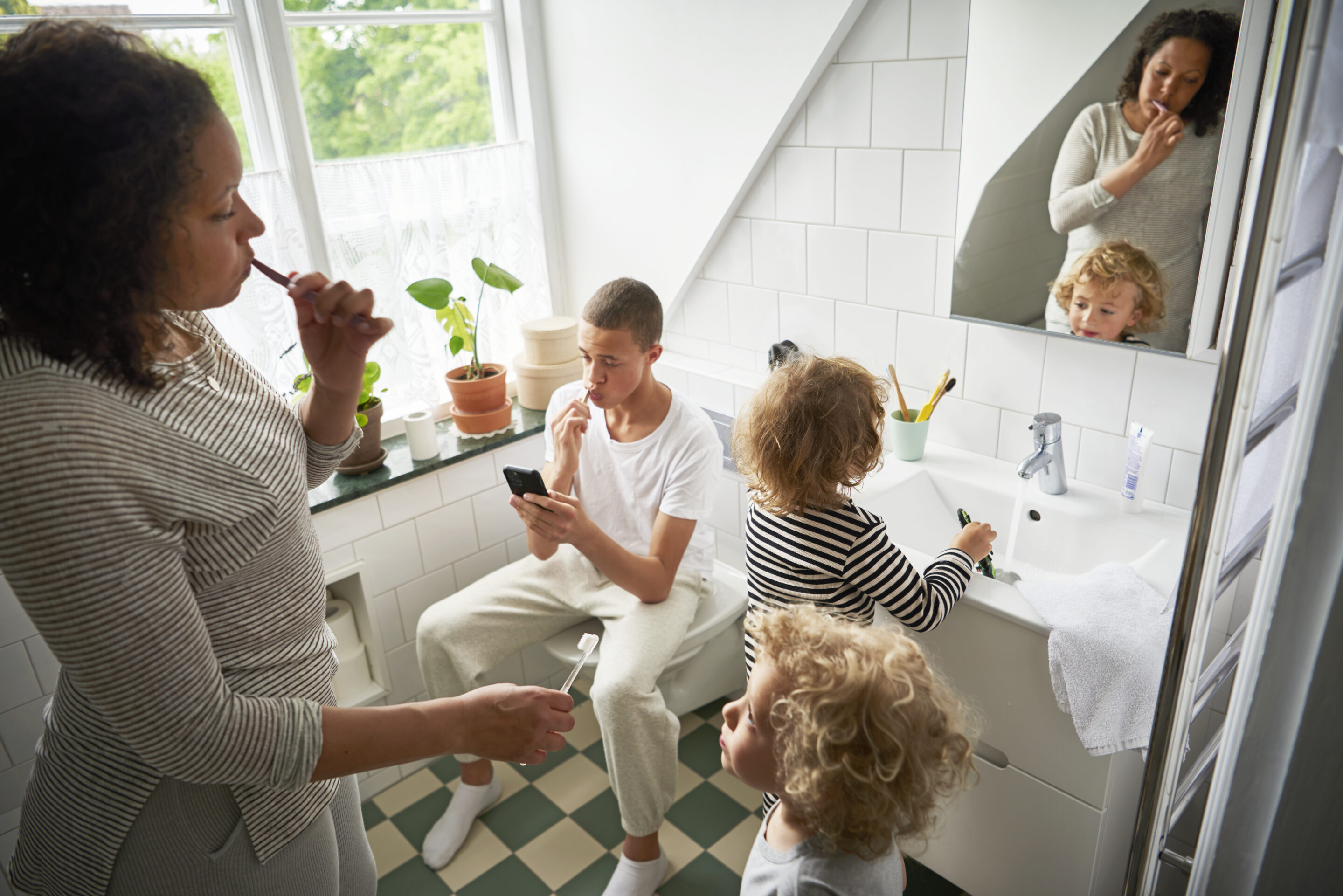 Mother and three children brush teeth in bathroom